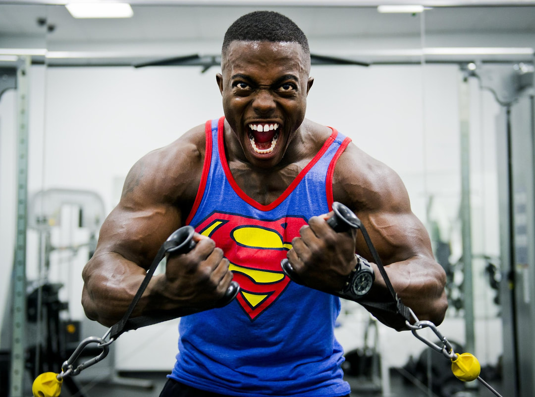 Man with superman shirt on lifitng weights
