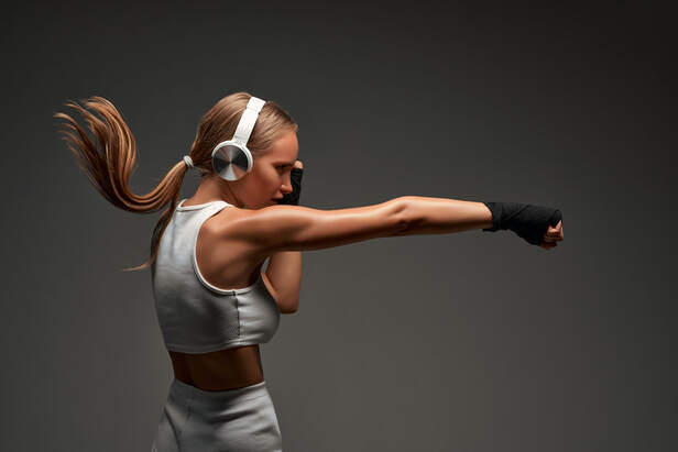 woman with headphones on boxing