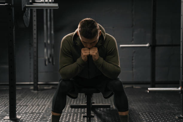 man resting his head on his hands after working out